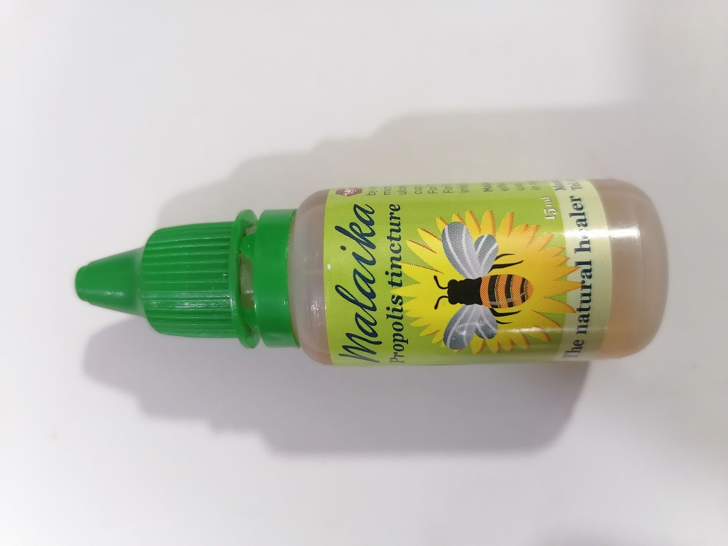 Bottle of Malaiika propolis tincture with a green cap on a white background