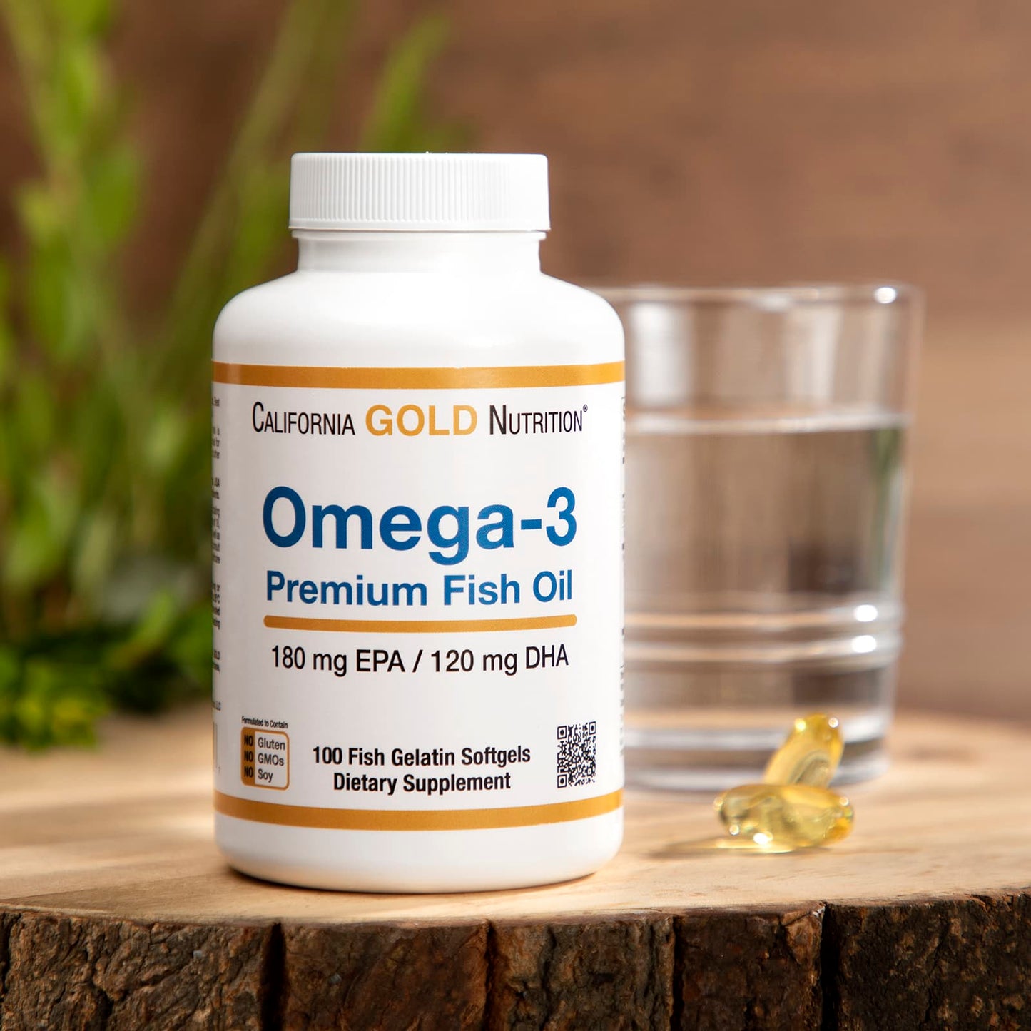Omega-3 fish oil supplement bottle with a glass of water on a wooden surface