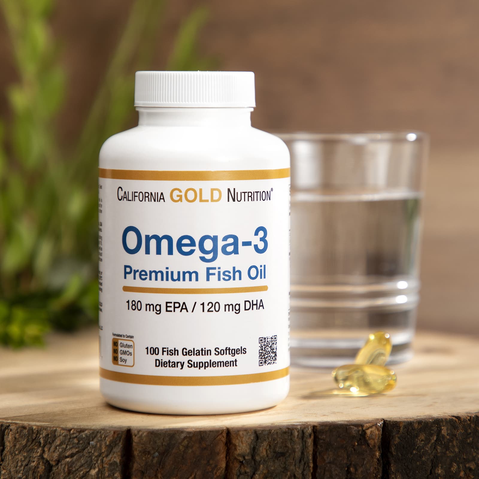 Omega-3 fish oil supplement bottle with a glass of water on a wooden surface