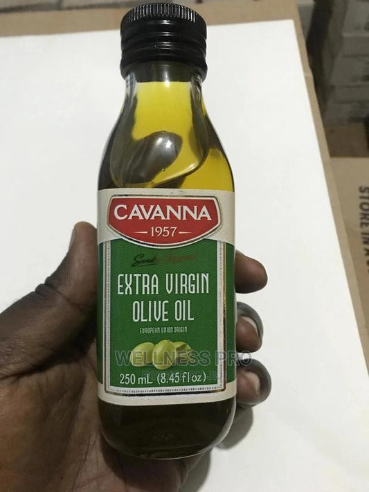 Bottle of Cavanna Extra Virgin Olive Oil held by a hand on a white surface