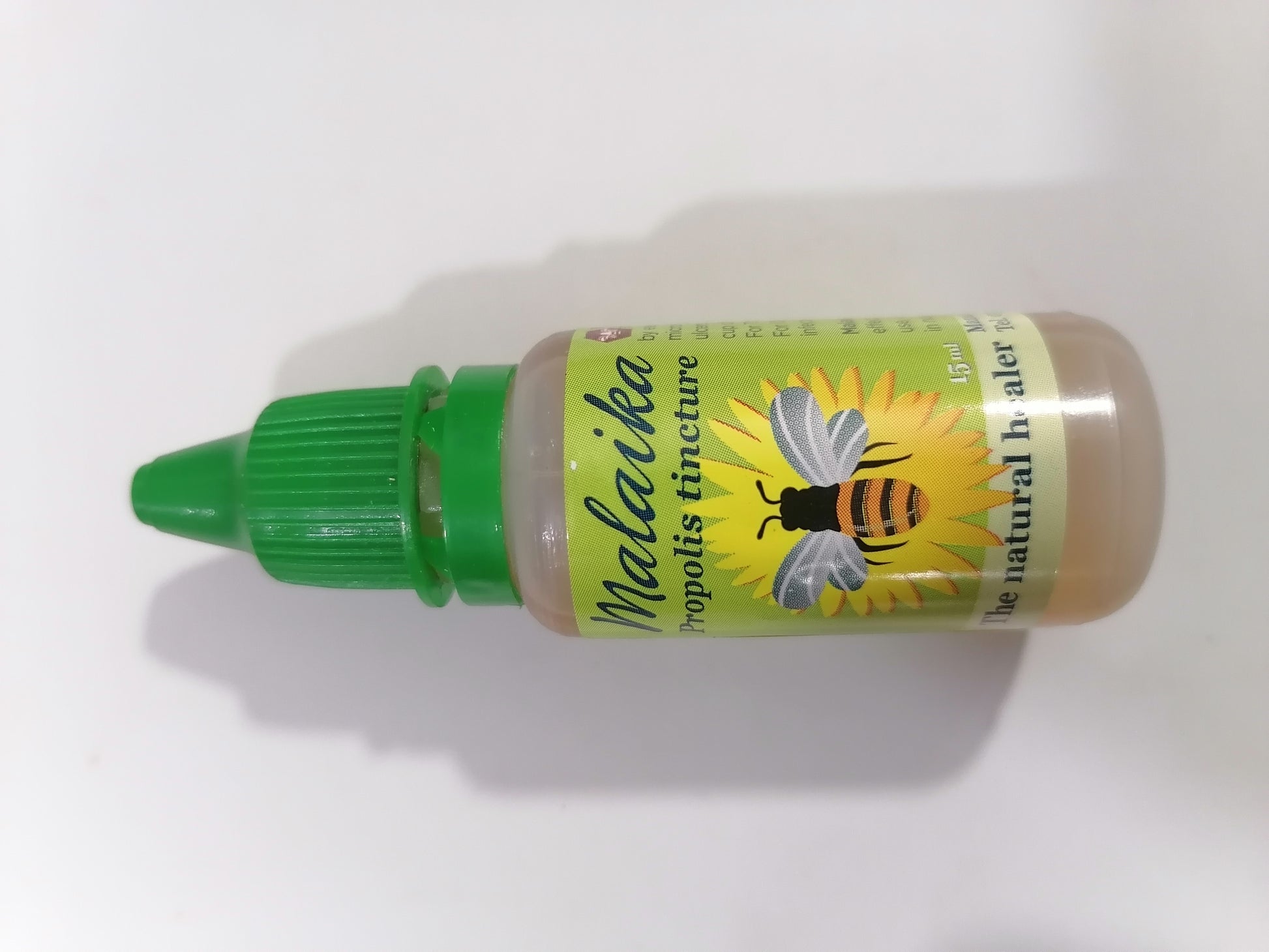 Bottle of Malaiika propolis tincture with a green cap on a white background
