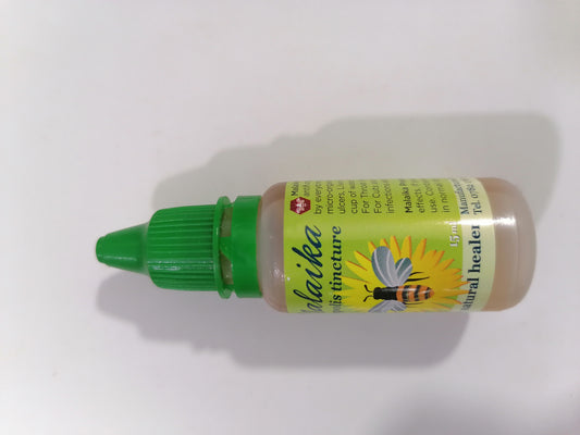 Bottle of herbal medicine with a green cap on a white background