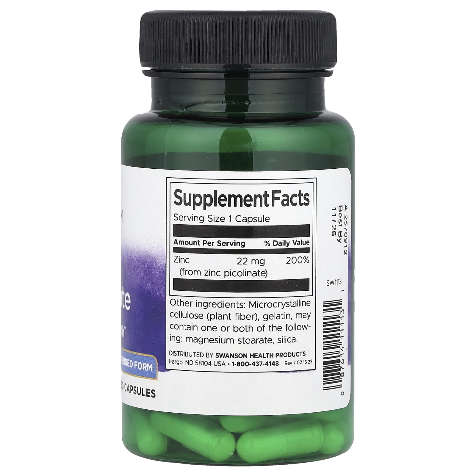 Supplement bottle with green capsules and a black lid on a white background