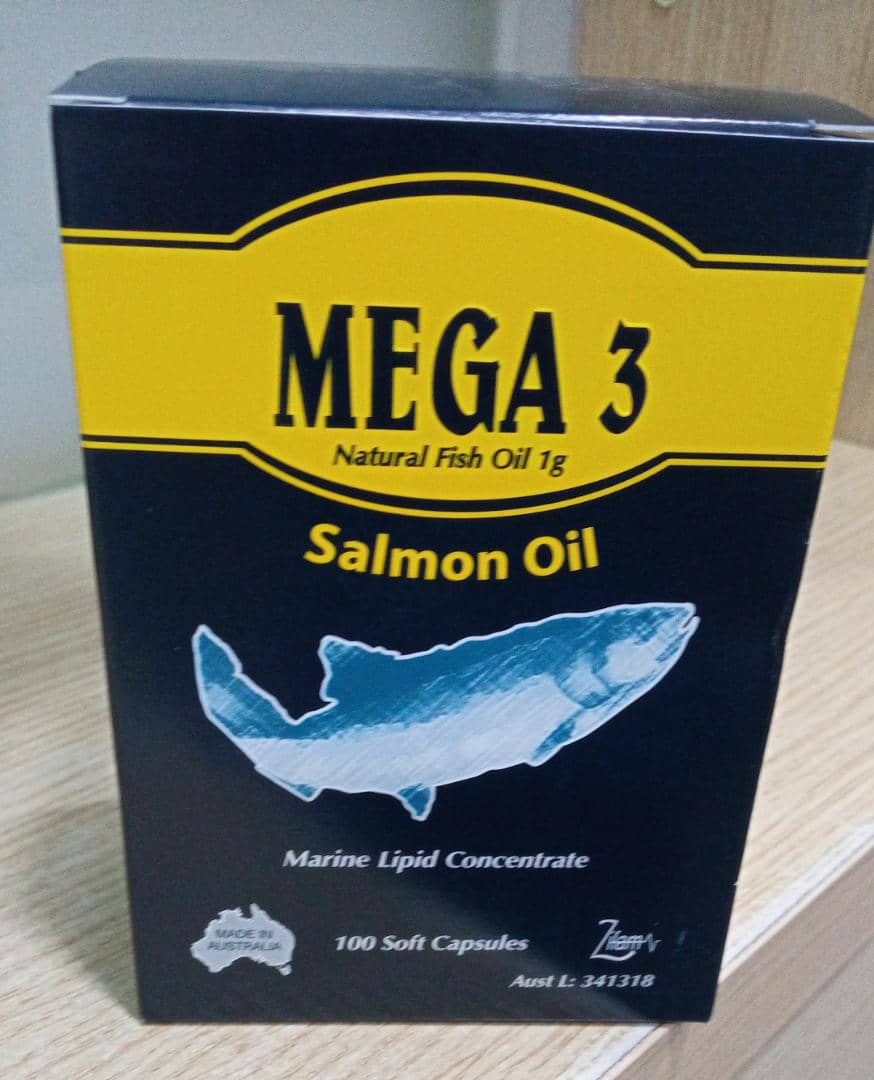 Box of Mega 3 Natural Fish Oil with salmon illustration on a wooden surface