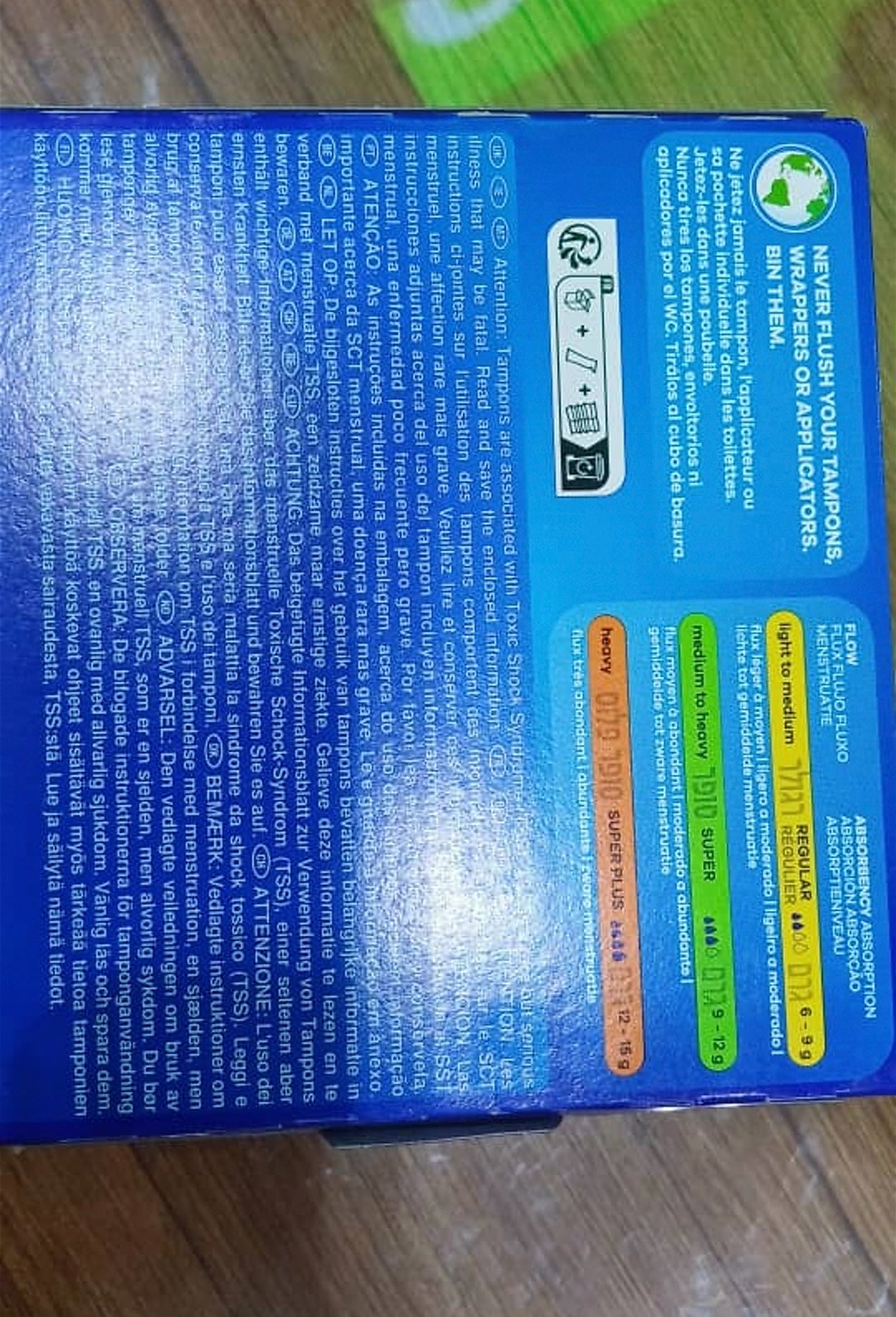 Blue box with text and a green label on a wooden surface