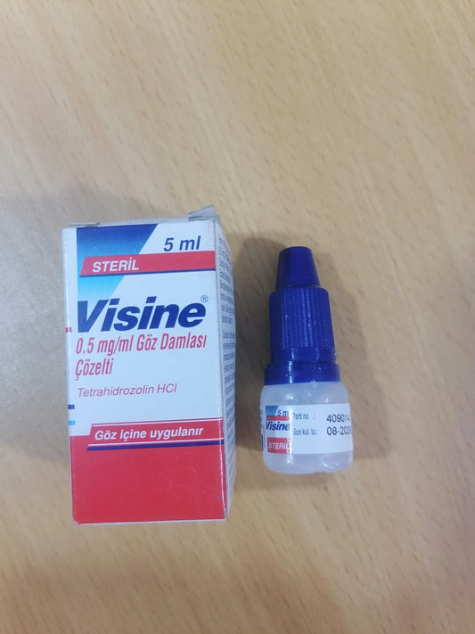 Visine eye drops and packaging on a wooden surface