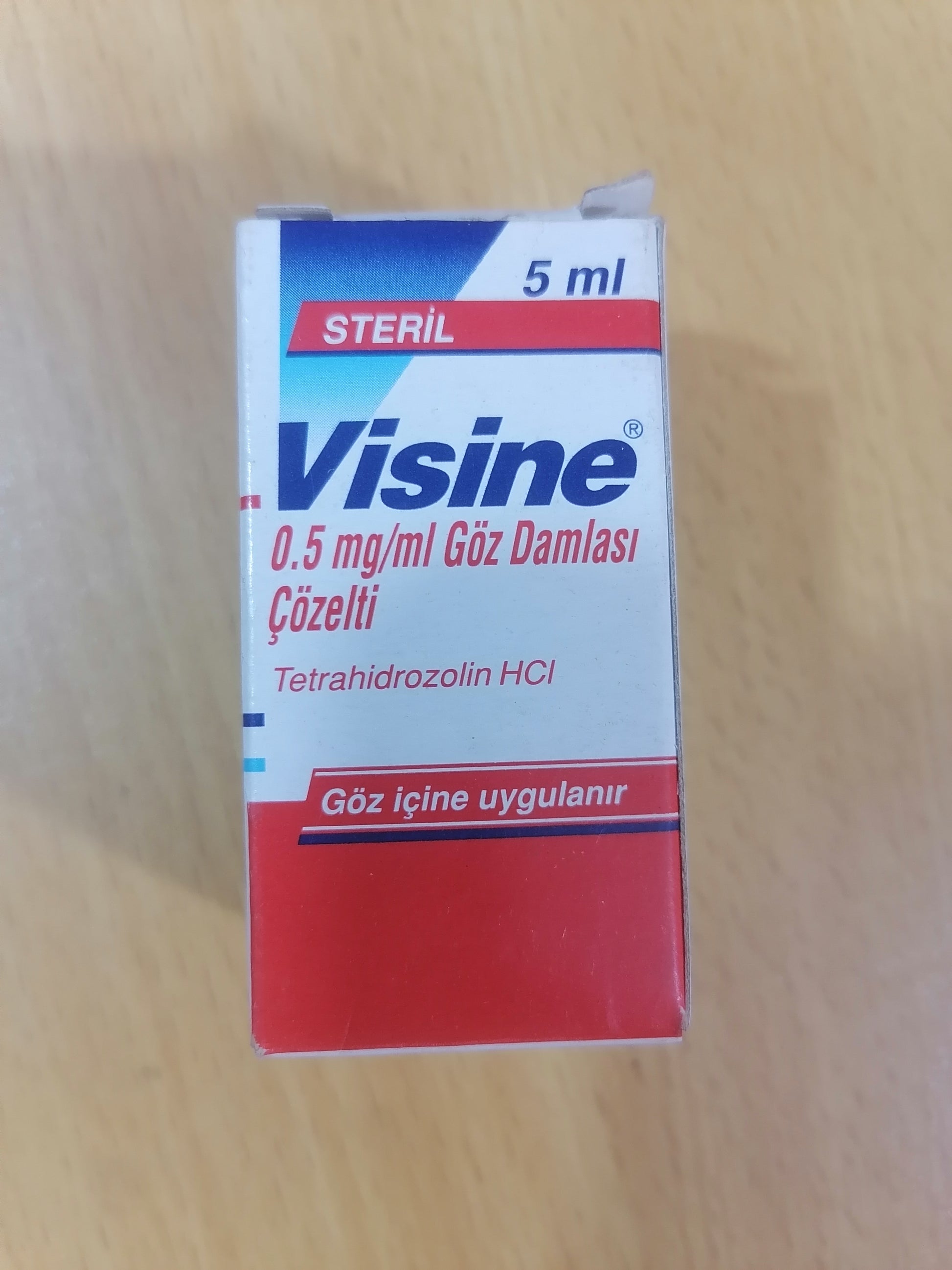 Visine eye drop box on a wooden surface